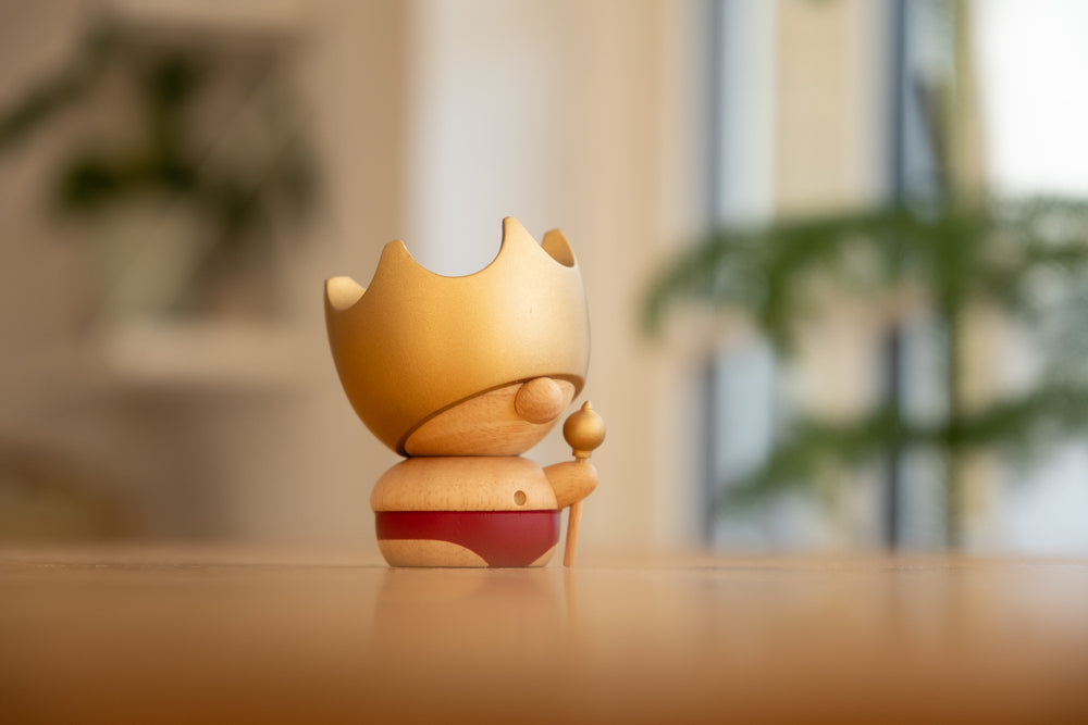 
                  
                    Kejserens nye klæder figuren som dekoration i spisestuen. Står i solskin på et bord med planter i baggrunden.
                  
                