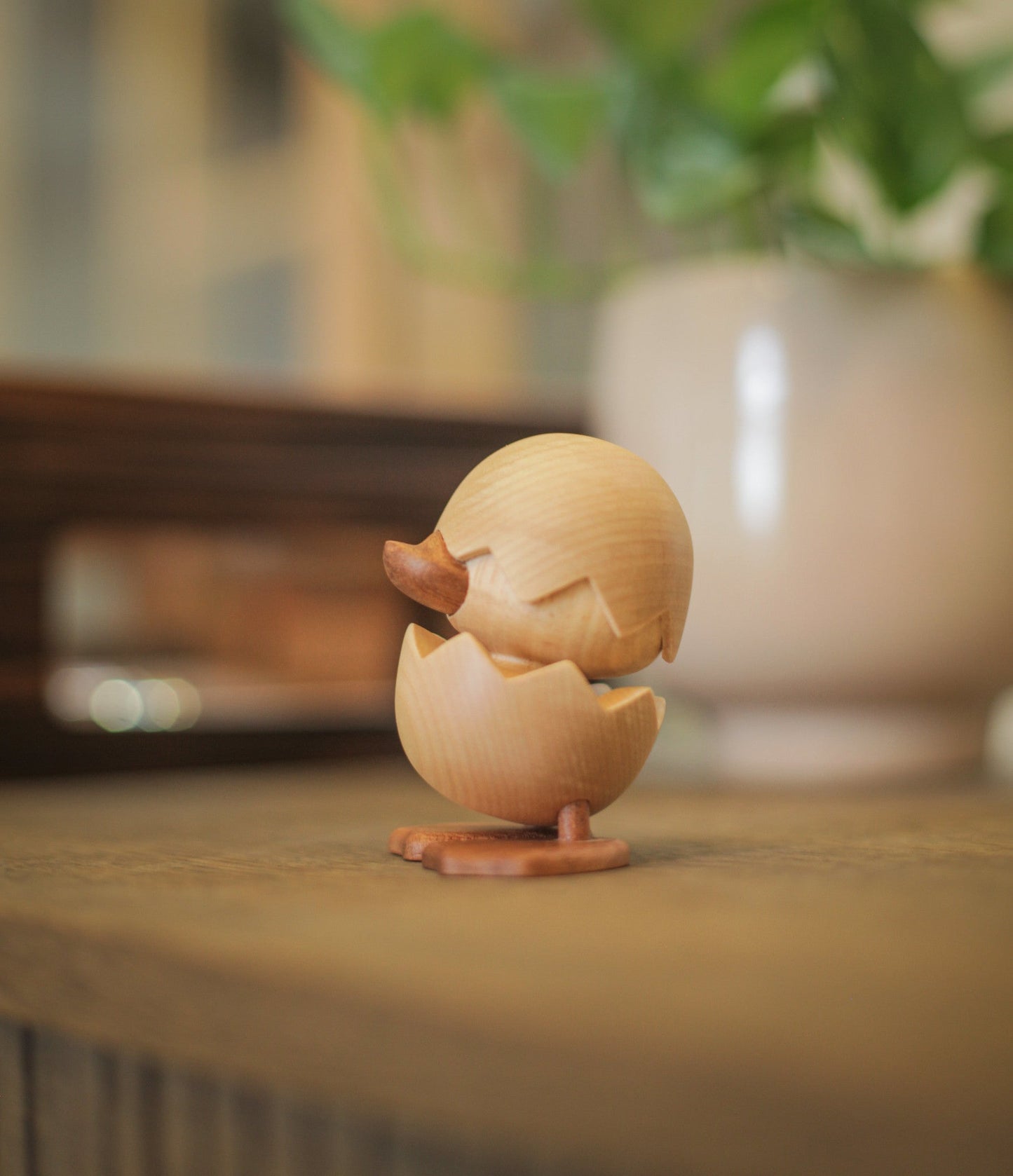 
                  
                    Den grimme ælling figuren på kommode. Pynter om dekoration sammen med planterne i baggrunden. 
                  
                